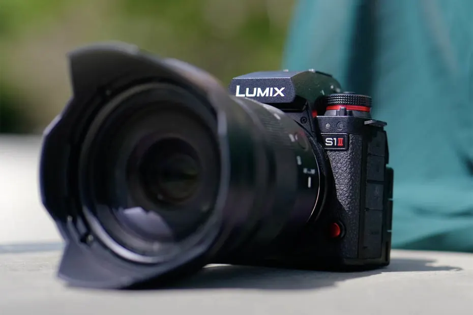 Lumix S1 II avec son pare-soleil, posé sur une table en extérieur